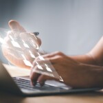 main tapotant sur un ordinateur avec image en ologramme