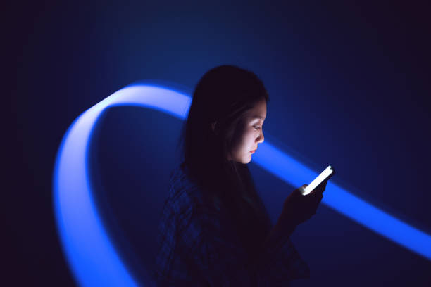 femme de profil avec un téléphone dans les mains