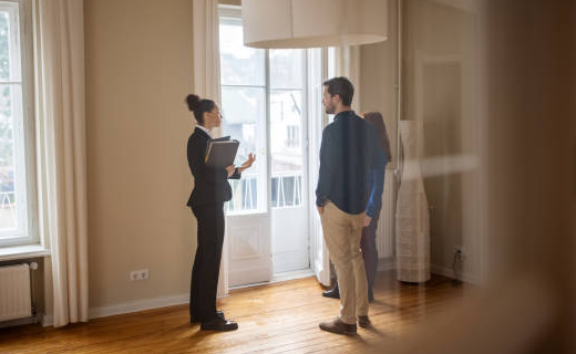 Une agent immobilier avec un couple de clients dans un appartement en visite