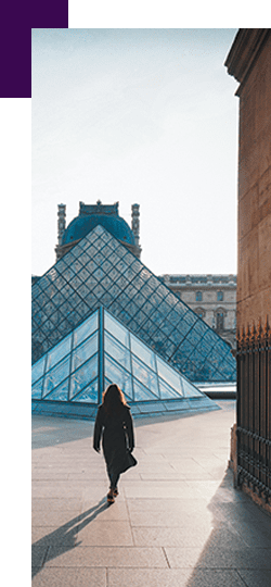 Femme qui marche vers les pyramides du Louvre à Paris